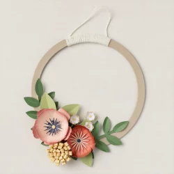 Image is of a simple wreath, plain circle with a large bunch of dark & light peach and yellow flowers to one side.  The flowers and leaves are artfully made from paper.  This is a photo of the finished product of the Stampn'Up wreath of blooms kit.