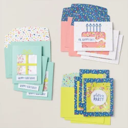 Image features three designs of birthday cards, one is a large cake, one is square with the words Let's party and the third is a see through window. Each card is a "shaker' card. 
 The colors are peach, white, dark blue, light blue and bright green/yellow. These are the cards featured in the Stampin'Up Confetti Birthday Card Making Kit.