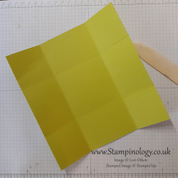 Image of a piece of lime green cardstock with the score lines described burnished in.
