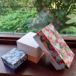 The image is a photograph of three different sized boxes in different patterned papers.